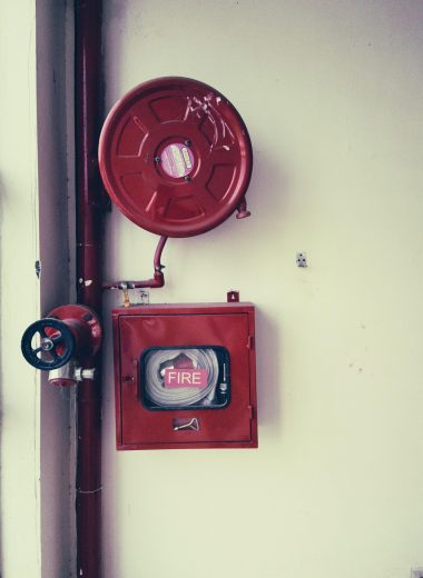 Red fire safety equipment on a white wall, essential for emergencies.